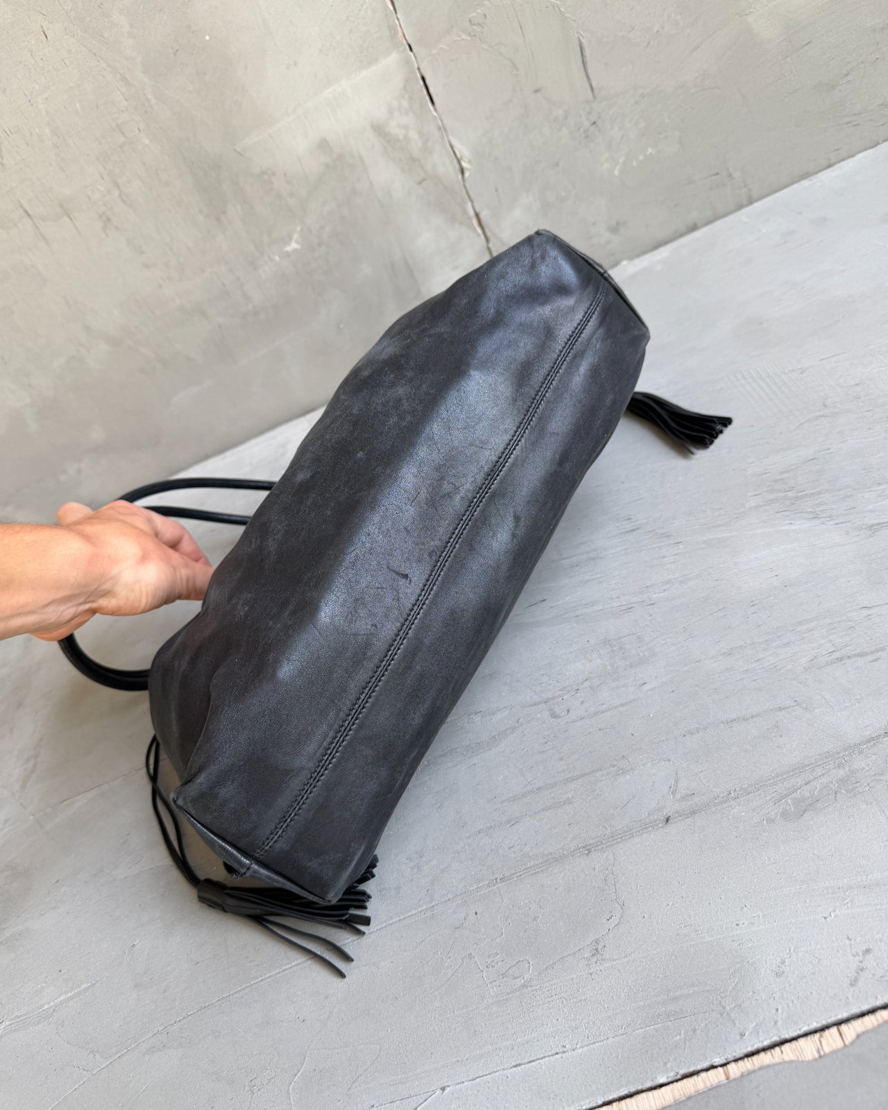 Gucci Black Leather Bag-on a concrete background
