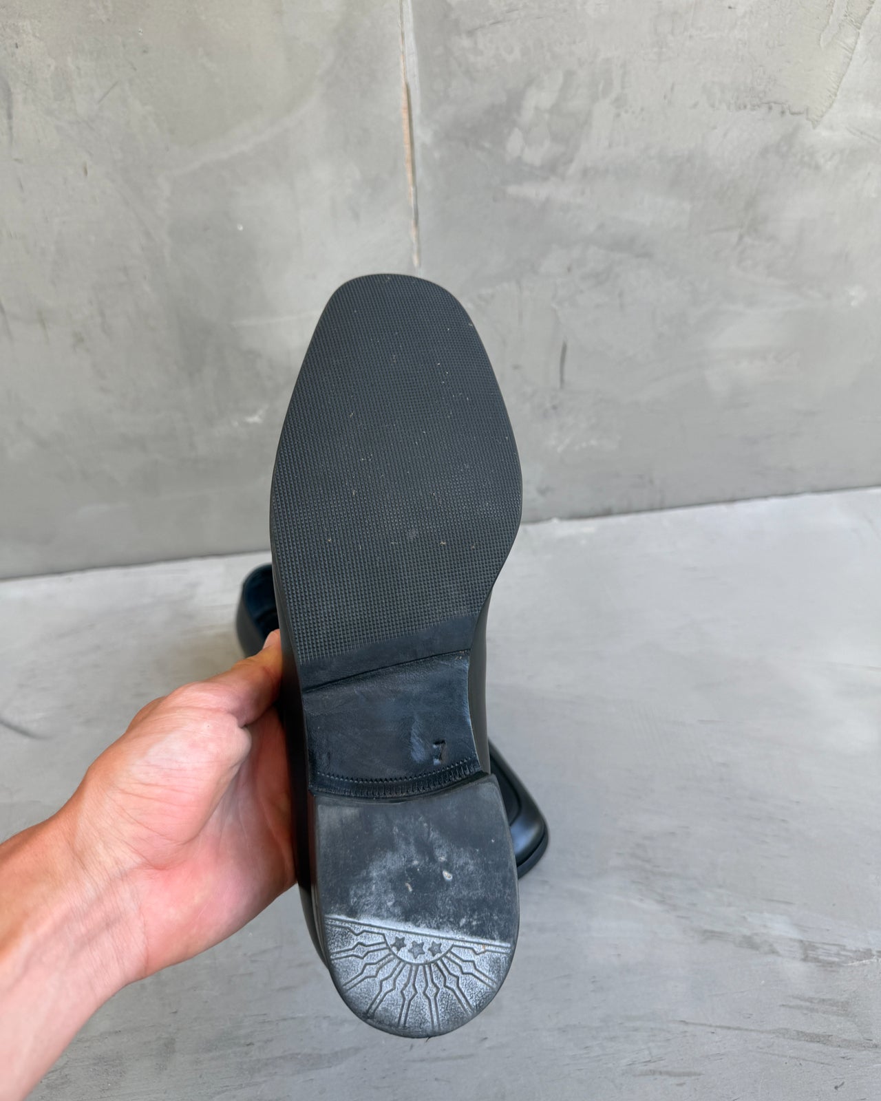 Prada Black Leather Loafers – UK 7-on a concrete background