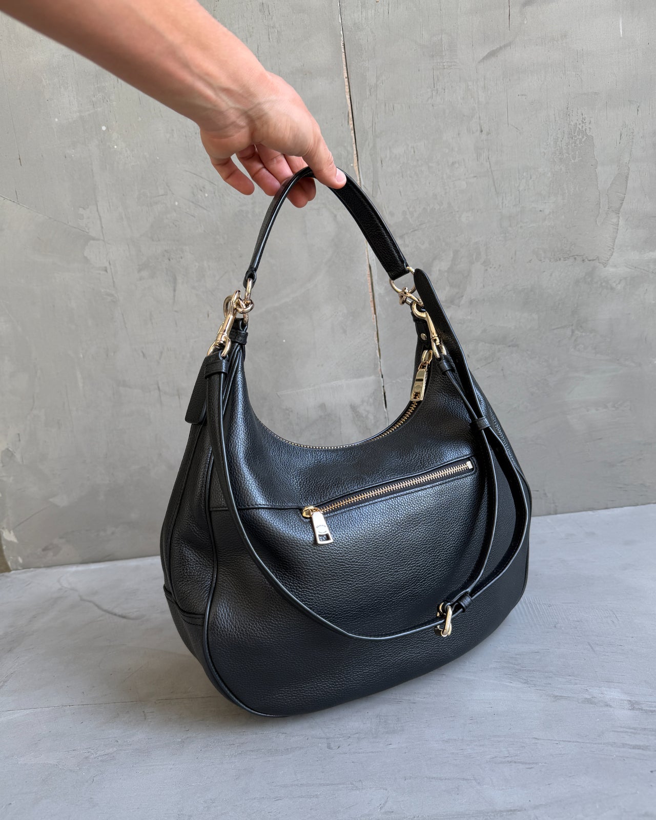 Coach Black Leather Shoulder Bag with Crossbody Strap-on a concrete background