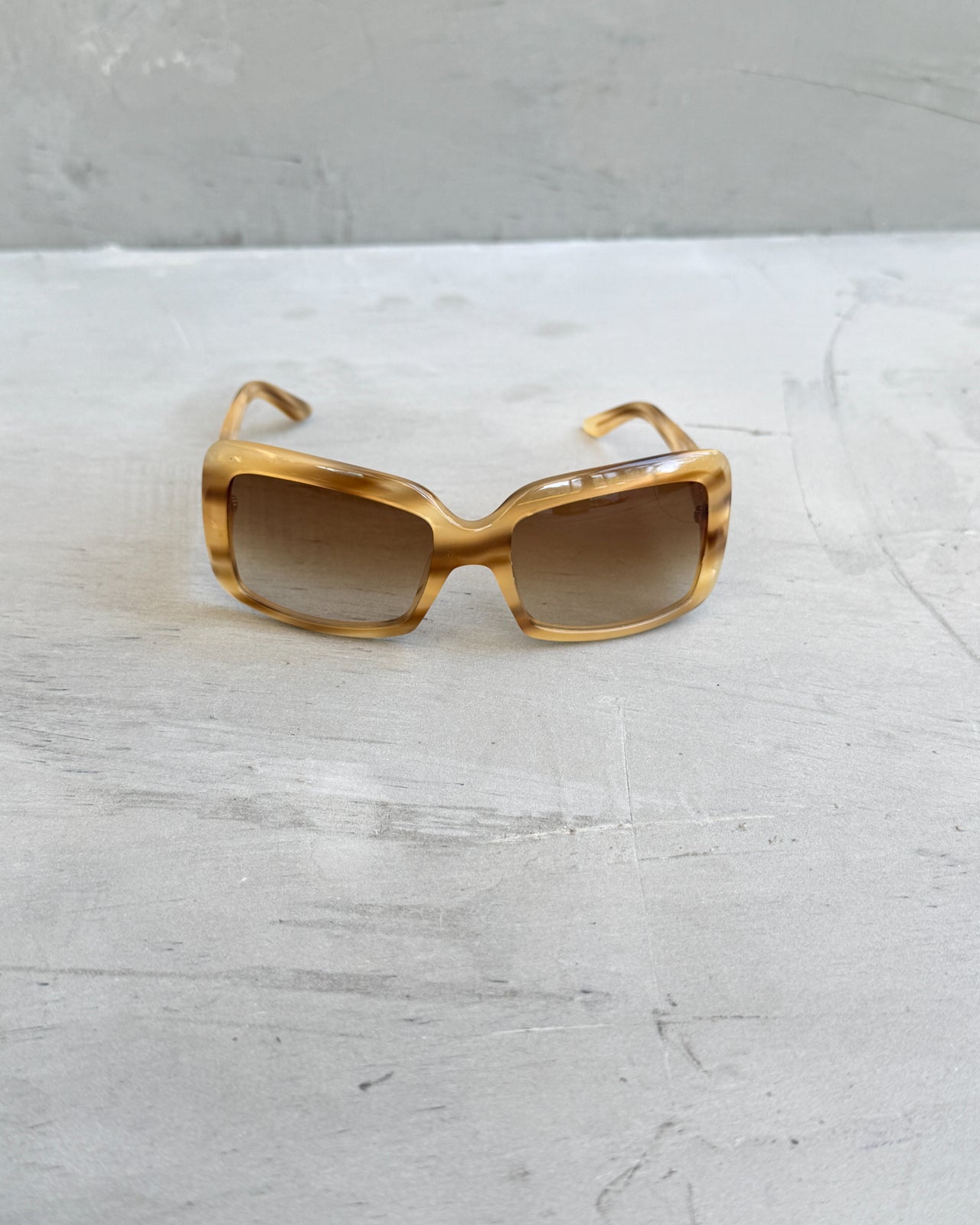 Miu Miu Beige and Brown Tortoiseshell Sunglasses-on a concrete background