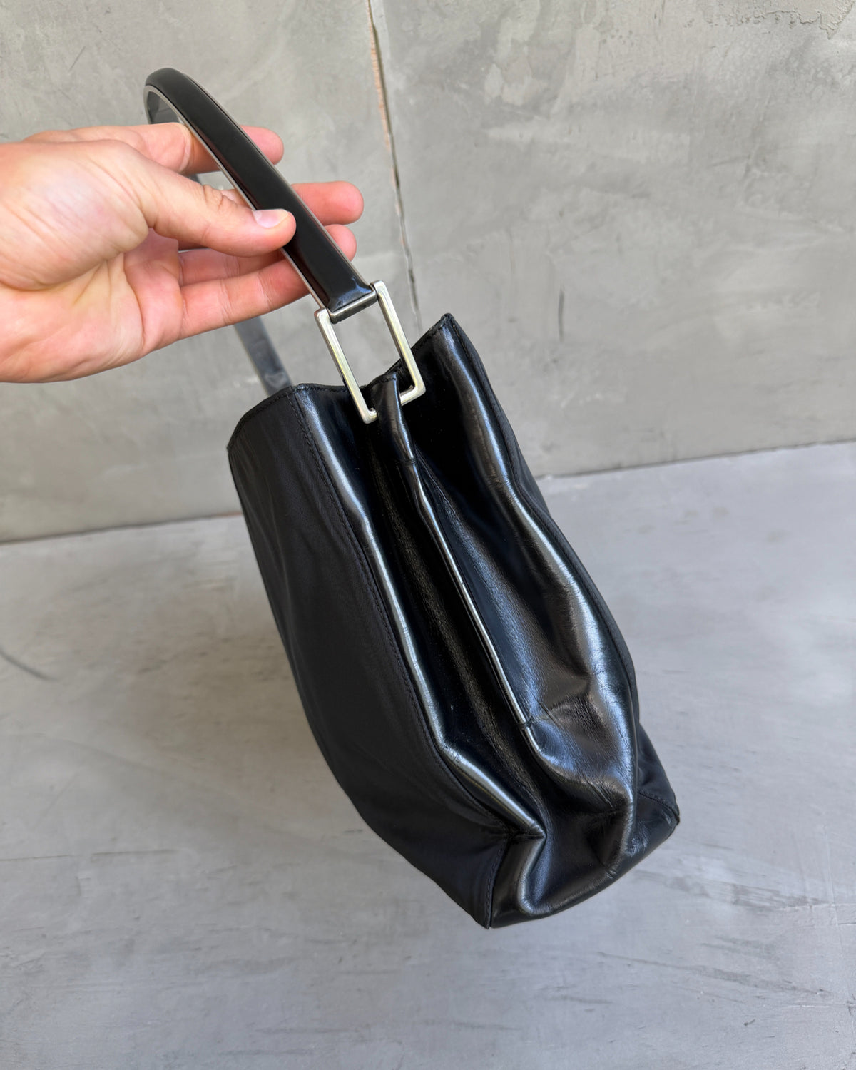 Prada Black Nylon and Leather Shoulder Bag-on a concrete background