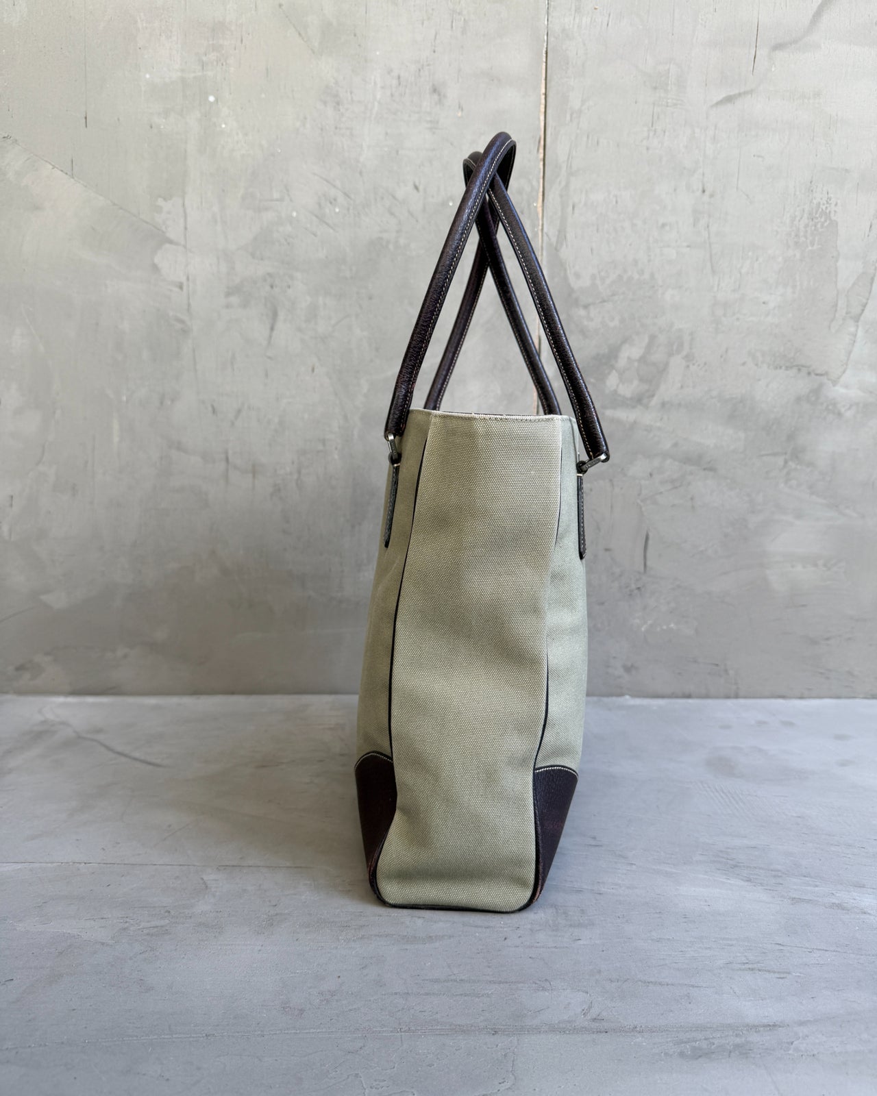 Prada Canvas and Leather Tote Bag-on a concrete background