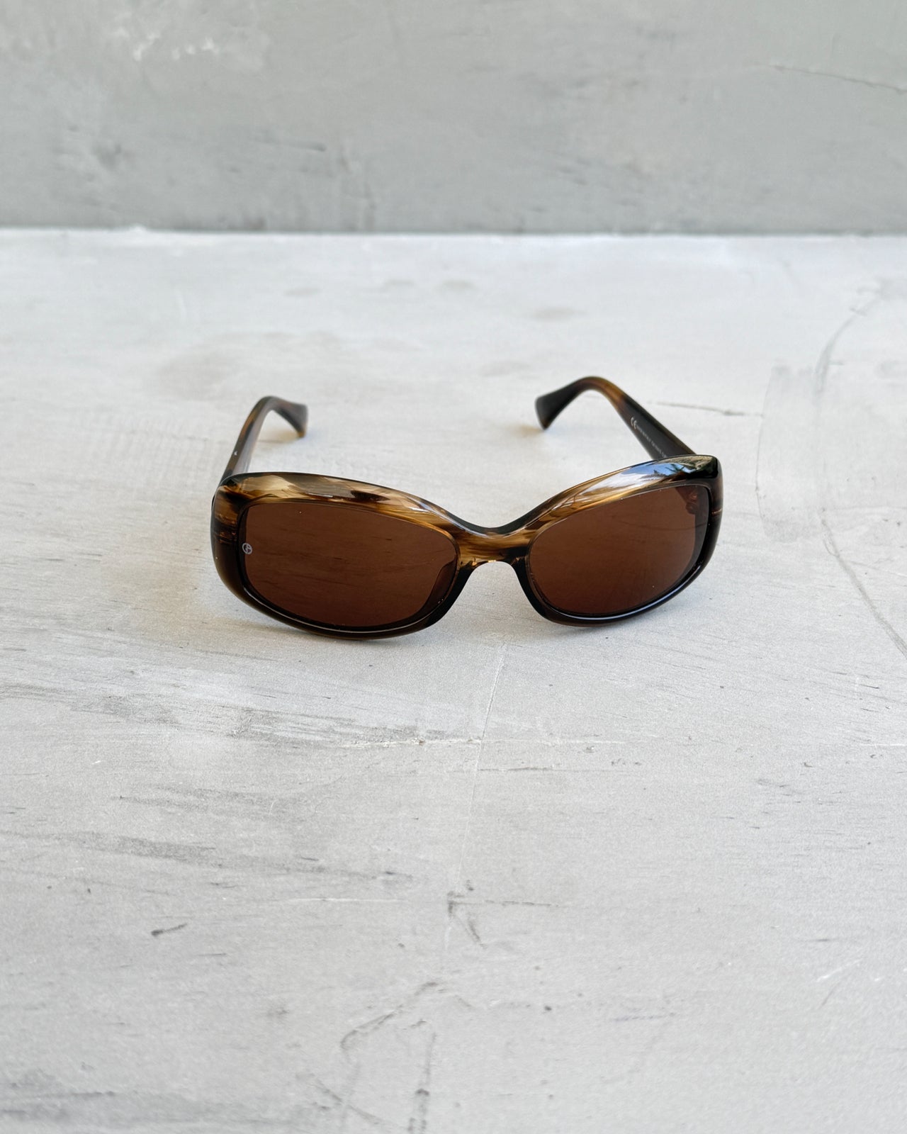 Giorgio Armani Oval Tortoiseshell Sunglasses-on a concrete background